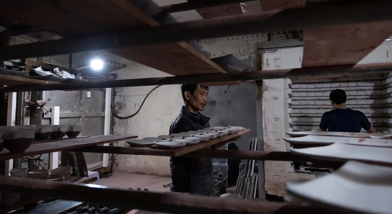 A craftsman carrying porcelain to the kiln