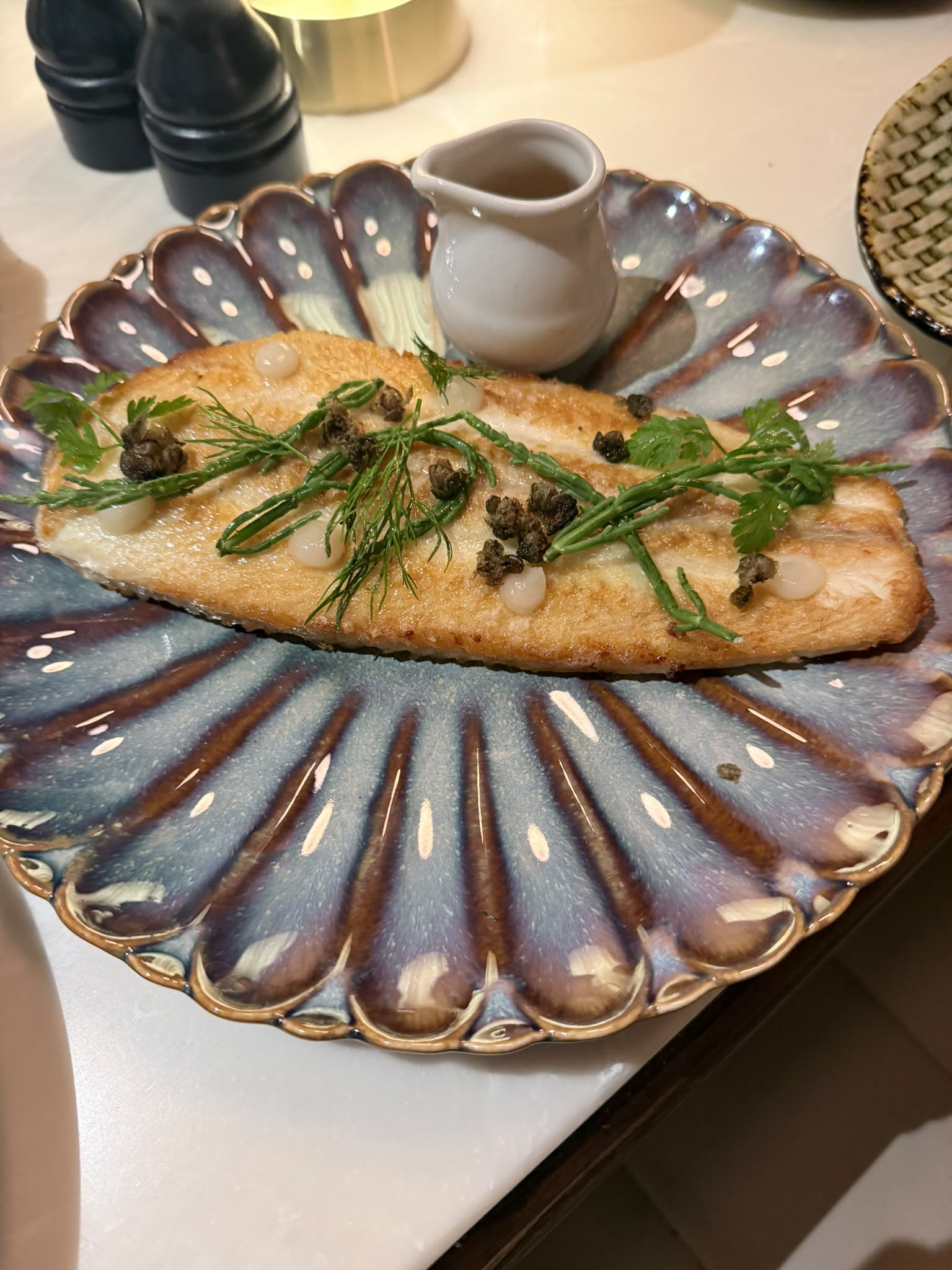 Pan-fried fish with capers and samphire on a blue fluted Annamis plate