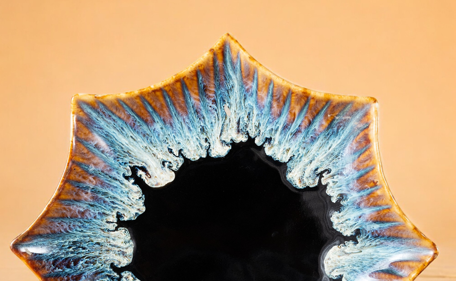 A Deep Ocean tumbler with teal glaze breaking to foam over a near-black body